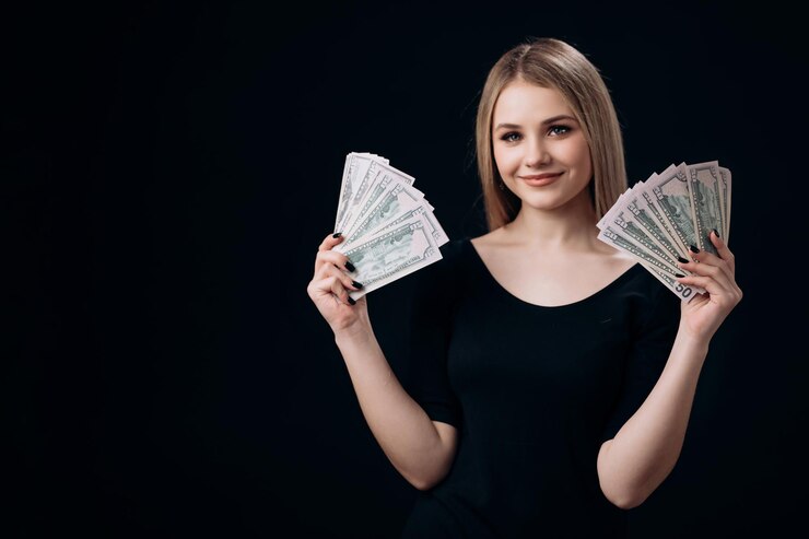 Atractiva mujer sosteniendo billetes de un dólar