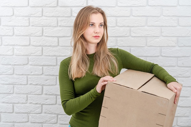 Atractiva mujer sosteniendo una caja de paquetes