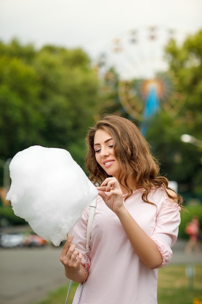 Atractiva mujer sosteniendo dulce algodón de azúcar