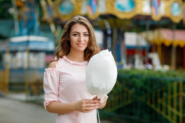 Atractiva mujer sosteniendo dulce algodón de azúcar