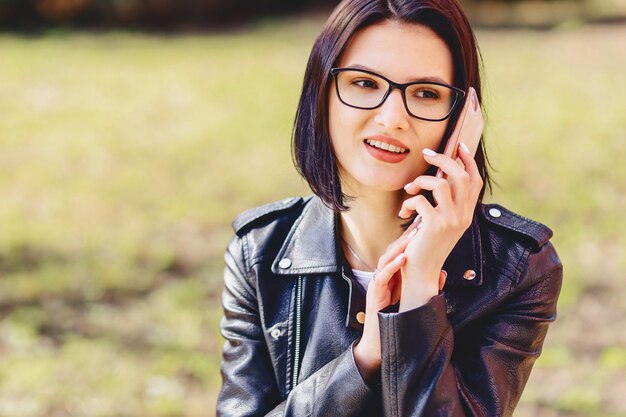 Atractiva niña sonriente habla por teléfono