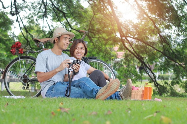 Atractiva pareja asiática que data en el concepto de relajación togetherness del parque