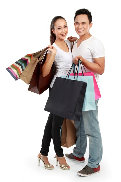 Atractiva pareja feliz llevando bolsa de compras