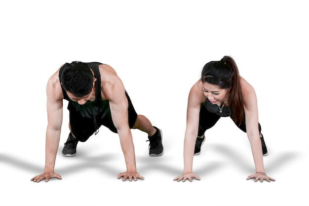 Atractiva pareja joven haciendo push up juntos