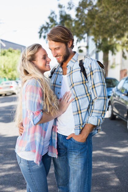 Atractiva pareja de pie y abrazos