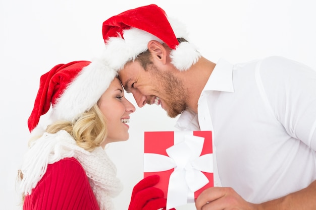 Atractiva pareja con sombreros de santa con regalo