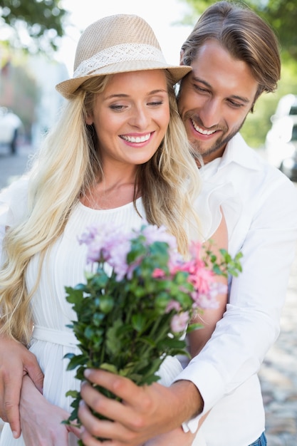 Foto atractiva pareja sonriendo a las flores