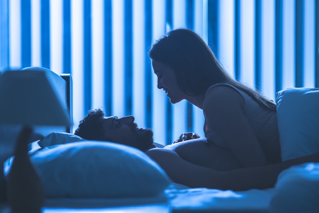 Foto la atractiva pareja yacía en la cómoda cama. noche