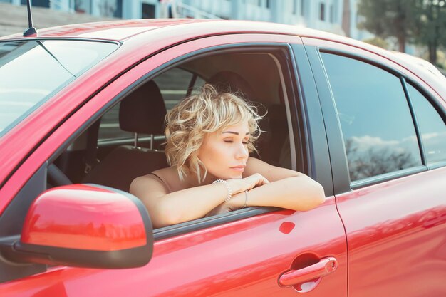 Atractiva rubia en un auto mostrando llaves