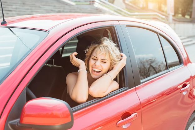 Atractiva rubia en un auto mostrando llaves