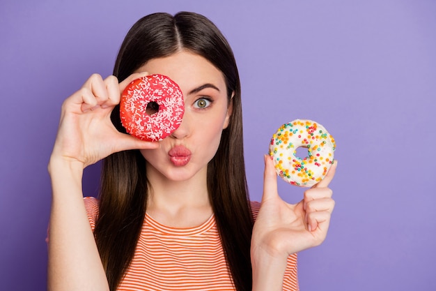 Atractiva señora loca sostener donas glaseadas escondiendo ojos enviar beso al aire