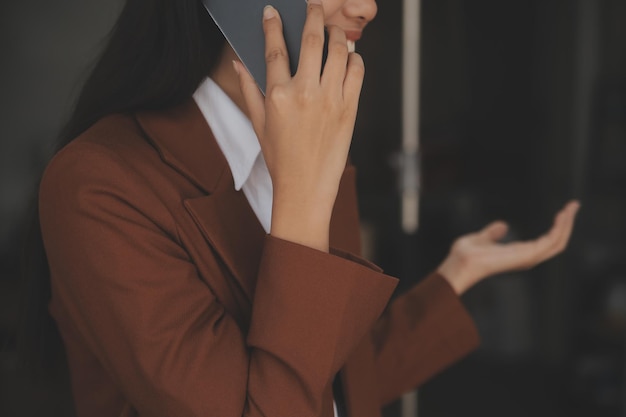 Atractiva y sonriente mujer de negocios asiática joven que trabaja en la oficina en casa Mujer asiática que trabaja en una computadora portátil con tableta