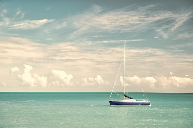 Foto atractiva vista brillante de la hermosa playa marina exótica y colorida con barco en agua azul