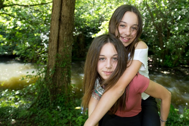 Atractivas hermanas gemelas Cerca de dos hermosas mujeres jóvenes sonrientes de pie juntas