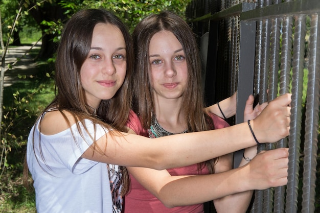 Foto atractivas hermanas gemelas cerca de dos hermosas mujeres jóvenes sonrientes de pie juntas