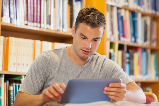 Atractivo estudiante casual usando tableta