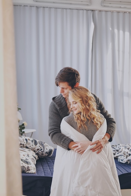 Foto atractivo hombre y mujer en el dormitorio juntos abrazos lindo