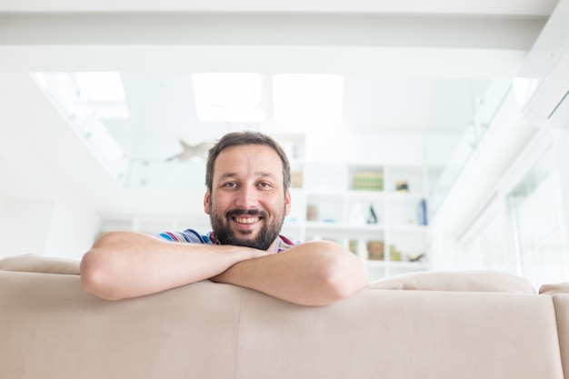 Atractivo hombre sonriente relajante en casa