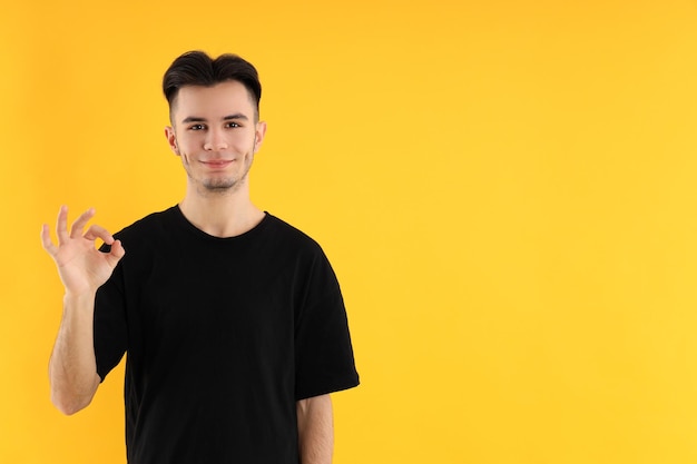 Atractivo joven en camiseta sobre fondo amarillo