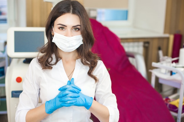 Atractivo joven médico. Retrato de mujer con guantes de goma y máscara.