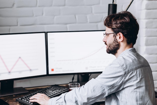 Atractivo joven trabajando en una computadora