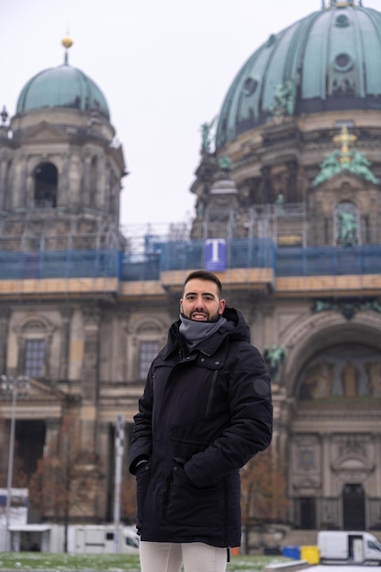 Foto atractivo joven turista masculino con barba y catedral de berlín al fondo