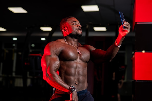 Atractivo modelo de fitness afroamericano se toma selfie en el fondo del gimnasio Foto para redes sociales Primer plano