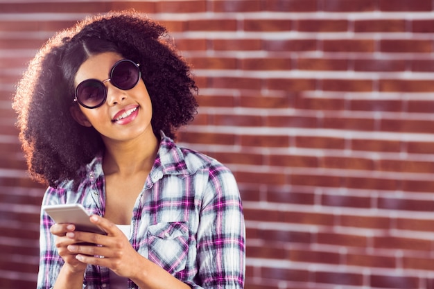 Atractivo sonriente hipster con smartphone