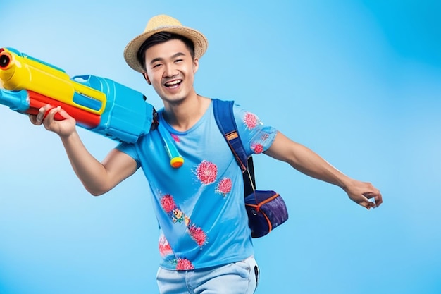 Un atractivo turista asiático que viaja con una pistola de agua y equipaje durante el festival de Songkran fue filmado en un estudio con fondo azul.