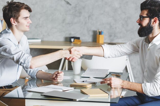 Foto atractivos empresarios dándose la mano