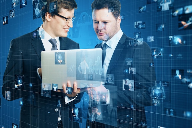 Atractivos hombres de negocios europeos que usan una computadora portátil junto con la conexión de metaverso de tecnología de empresarios y el concepto de videoconferencia Imágenes creativas conectadas en un fondo azul borroso