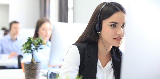 Atractivos jóvenes empresarios y colegas positivos en una oficina de centro de llamadas