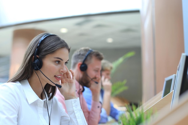 Atractivos jóvenes empresarios y colegas positivos en una oficina de centro de llamadas.