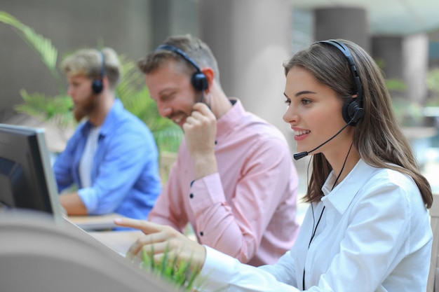 Atractivos jóvenes empresarios y colegas positivos en una oficina de centro de llamadas