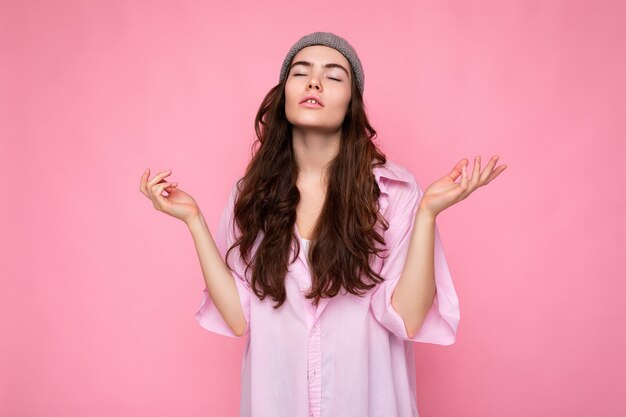 Atraente concentrado calmo fofo adorável concurso jovem morena encaracolada mulher vestindo camisa rosa