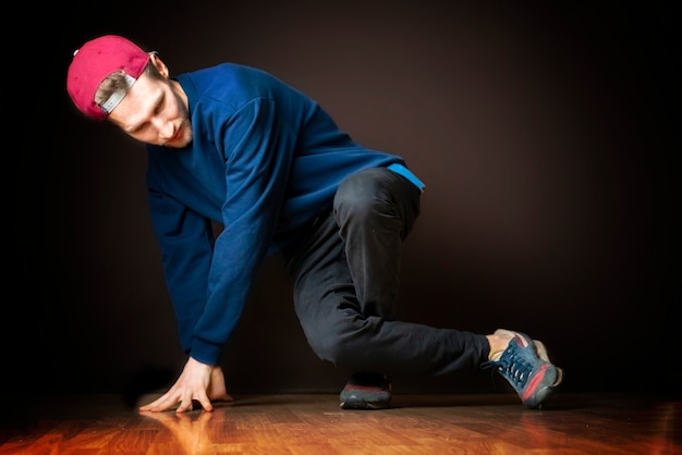 Atraente dançarino de rua masculino executa dança break footwork b