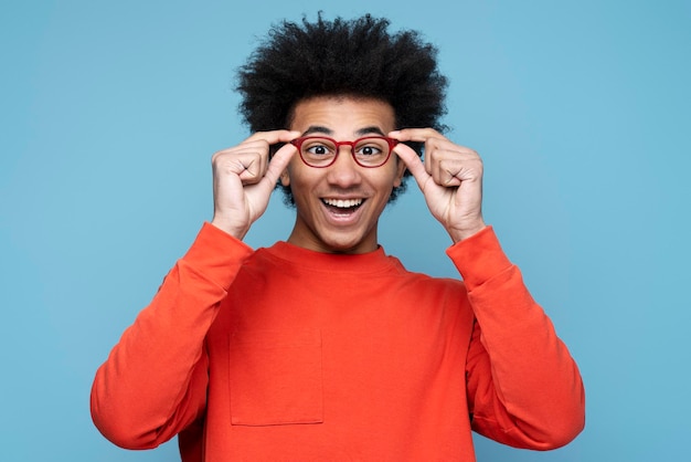 Atraente homem afro-americano engraçado vestindo elegante isolado no fundo azul, conceito de visão