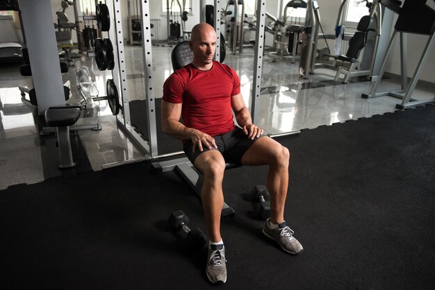 Atraente jovem descansando no ginásio após o exercício