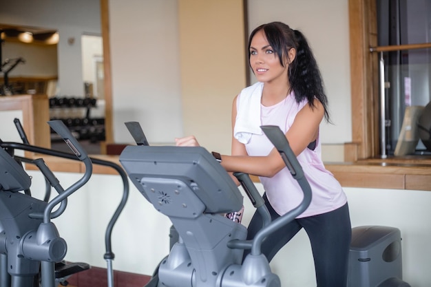 Atraente jovem desportista está malhando na academia