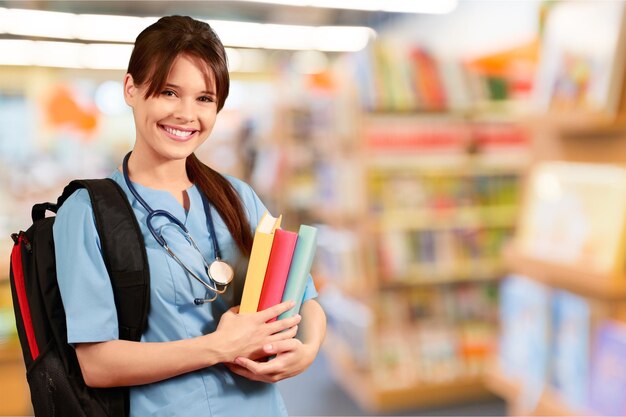 Atraente jovem estudante de medicina com mochila e livros