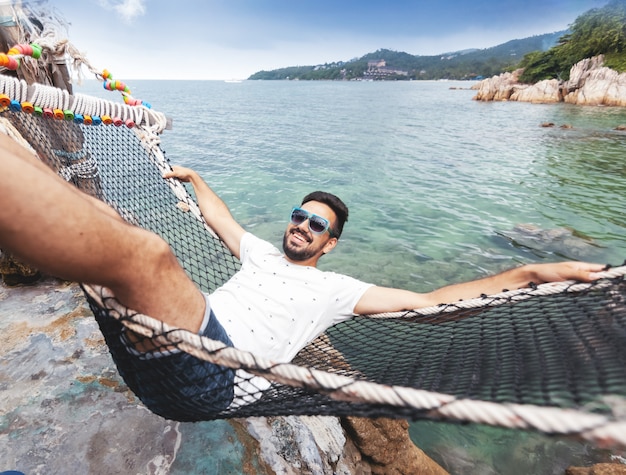 Foto atraente jovem latina morena homem bonito com uma barba na rede de férias