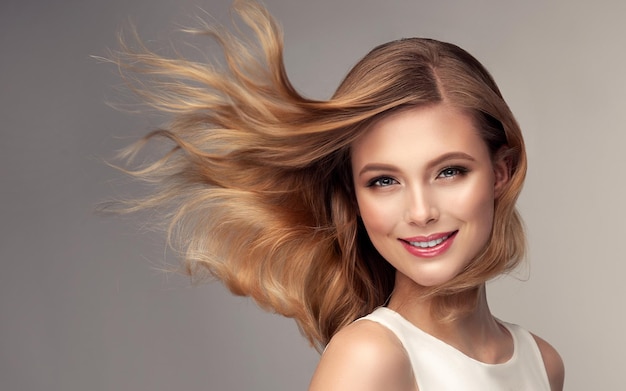 Foto atraente jovem loira com cabelo voador reto está usando uma elegante maquiagem noturna sorriso amável