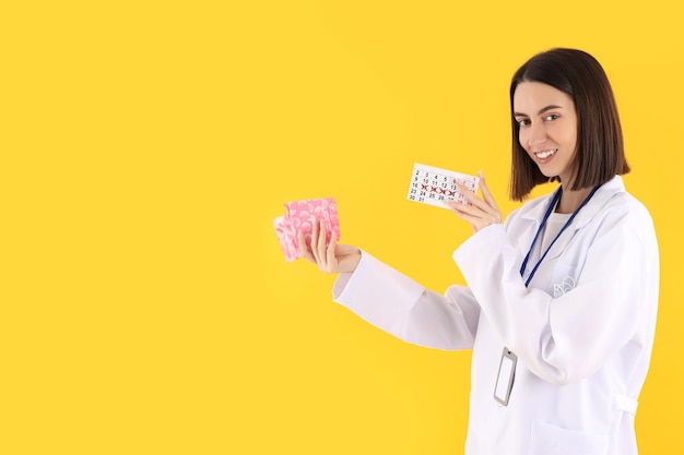 Foto atraente jovem médica em fundo amarelo