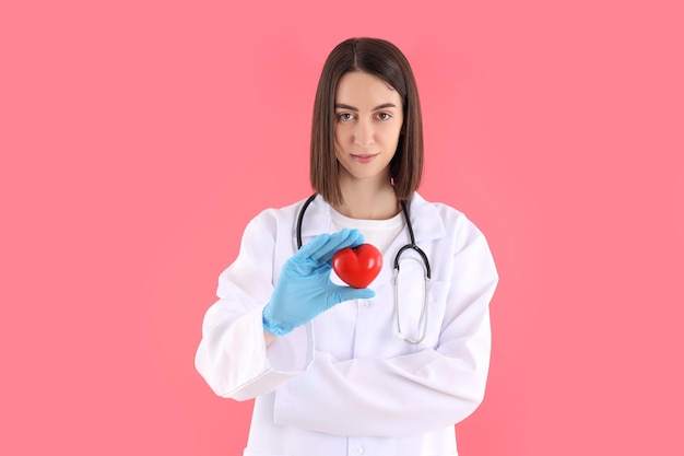 Atraente jovem médica em fundo rosa