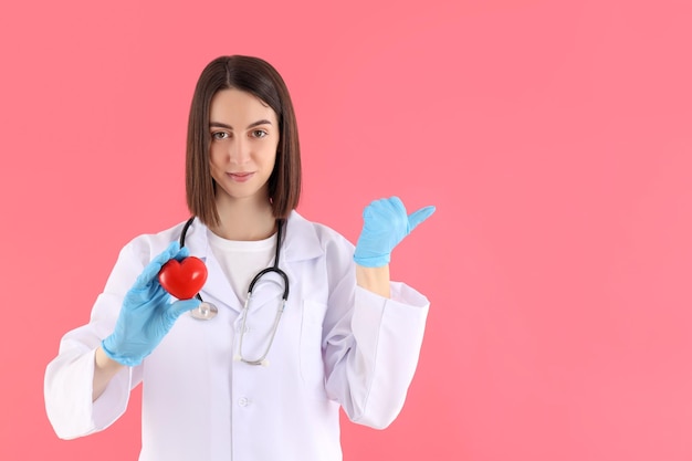 Atraente jovem médica em fundo rosa