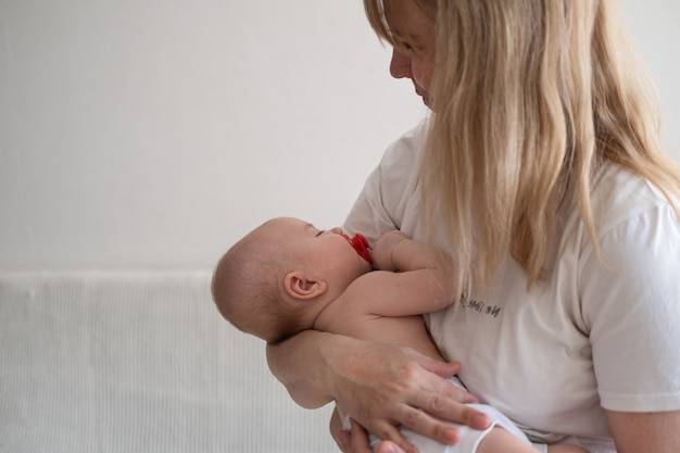 Atraente mãe feliz com o filho pequeno. criança dormindo. mãe amamentando bebê. amamentação. família feliz. em casa. amor. doce.