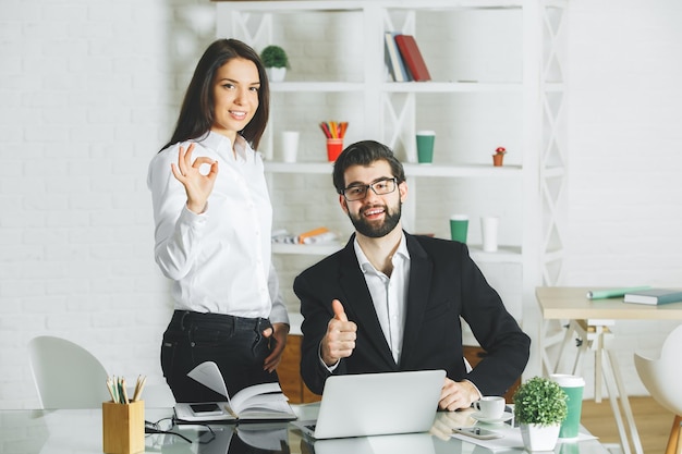 Atraente masculino e feminino, mostrando os polegares para cima