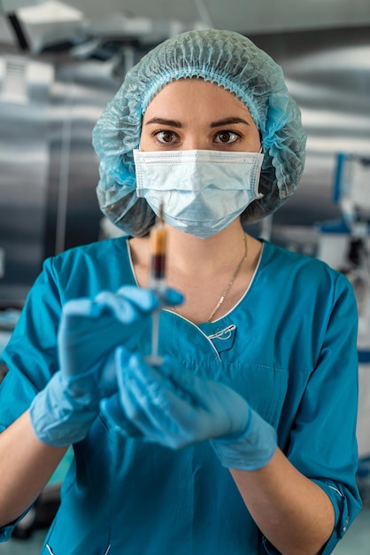Atraente médica segurando a seringa na sala de cirurgia para o paciente