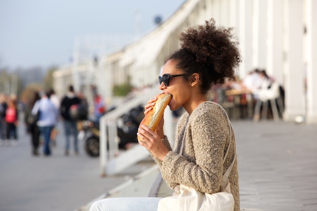 Atraente, mulher americana africana, comendo alimento, ao ar livre