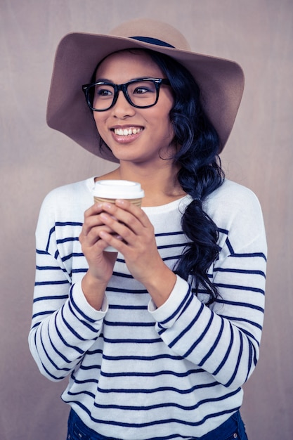 Atraente, mulher asian, com, chapéu, segurando, copo descartável, e, olhando